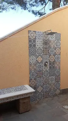 a tiled wall with a bench next to a building at ZE-VI HOME in Santa Flavia