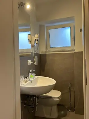 a bathroom with a sink and a toilet and a window at Like Home Palermo in Palermo