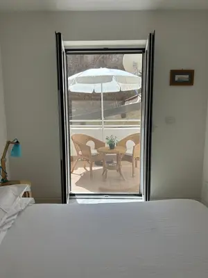 a bedroom with a door open to a patio with a table and umbrella at Like Home Palermo in Palermo