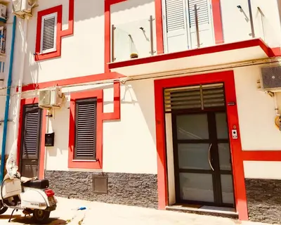 a scooter parked in front of a building with a door at Casa Escape in Terrasini
