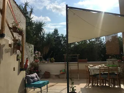 a patio with a table and a white canopy at Casa Escape in Terrasini