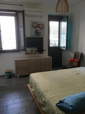 a bedroom with a bed and a flat screen tv at Casa Escape in Terrasini