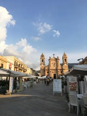 a street with tables and chairs in front of a building at Casa Escape in Terrasini