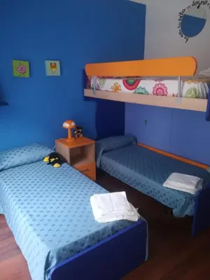 two beds in a room with blue walls at Casa Valire in Palermo