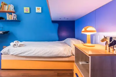 a bedroom with blue walls and a bed with a desk at Casa Valire in Palermo