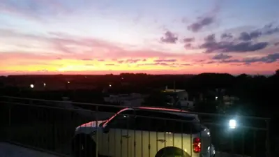 a bus driving down a road at sunset at Villa Cloe in San Vito lo Capo