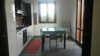 a kitchen with a table and some chairs and a window at Villa Cloe in San Vito lo Capo