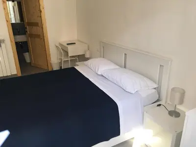 a bedroom with a large white bed and a table at FraLePorte in Palermo
