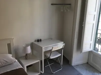 a white desk with a lamp and a chair in a bedroom at FraLePorte in Palermo