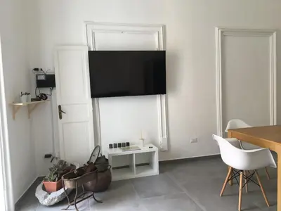 a living room with a flat screen tv on the wall at FraLePorte in Palermo