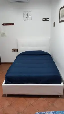 a bed with a blue blanket on top of it at A casa SCALILLA in Palermo
