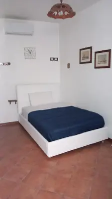 a bed in a white room with a blue mattress at A casa SCALILLA in Palermo