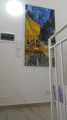 a painting hanging on a wall next to a staircase at CASA VACANZE DEL GOLFO 2 in Castellammare del Golfo