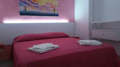 a bedroom with a red bed with two towels on it at CASA VACANZE DEL GOLFO 2 in Castellammare del Golfo