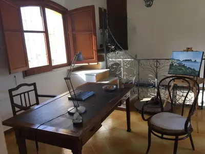 a room with a wooden table with chairs and a lamp at Casa al Bragone in Termini Imerese