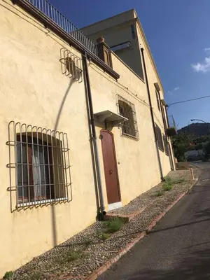 a building with barred windows and a red door at Casa al Bragone in Termini Imerese