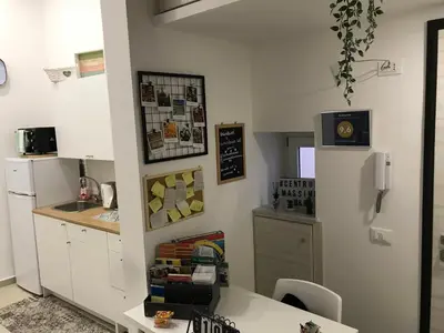 a kitchen with white cabinets and a table and a sink at centruMassimo b&b in Palermo