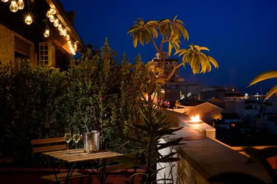 a table with wine glasses on a balcony at night at B&B AL PASSIO in Palermo