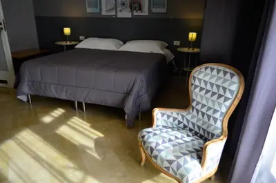 a bedroom with a bed and a chair at B&B AL PASSIO in Palermo