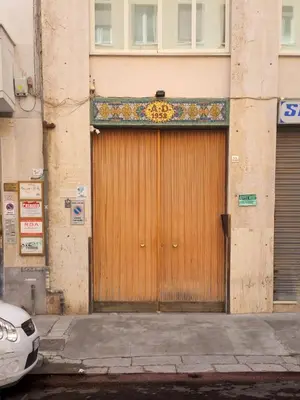 a wooden door on a building with a sign on it at Benvenuti al Massimo in Palermo