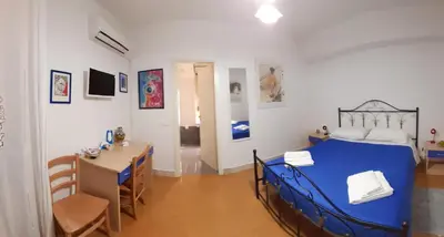 a bedroom with a blue bed and a table at Benvenuti al Massimo in Palermo