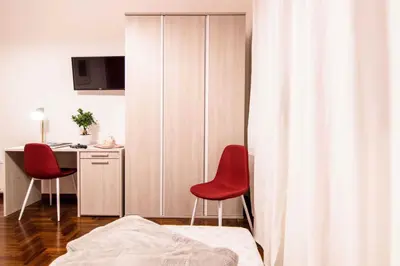 a bedroom with two red chairs and a desk at Tetide Home in Palermo