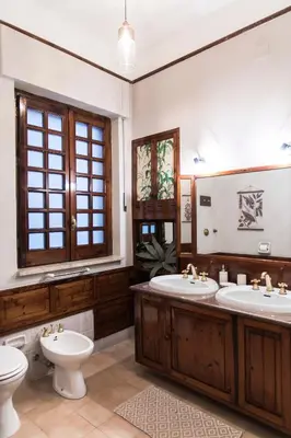 a bathroom with two sinks and a toilet at Tetide Home in Palermo