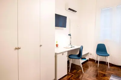 a room with a desk and two chairs at Tetide Home in Palermo