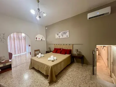a bedroom with a bed with red pillows at Rua House in Corleone
