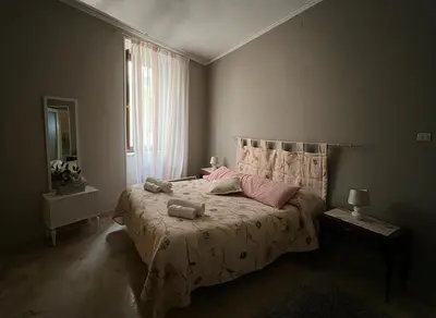 a bedroom with a bed with pink pillows and a window at Rua House in Corleone