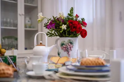 a table with a vase of flowers and plates of food at Scirocco House in Palermo