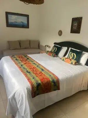 a large white bed with a colorful blanket on it at Domus Orestea Luxury Suites in Palermo