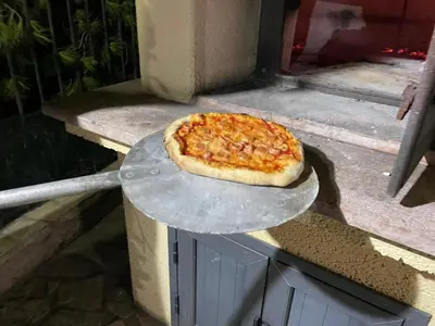 a pizza sitting on a plate on a table at Villino Giulia in Altavilla Milicia