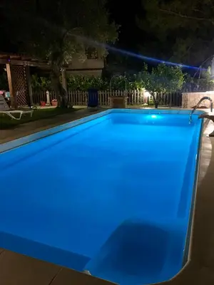 a blue swimming pool at night at Villino Giulia in Altavilla Milicia