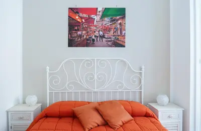 a bedroom with an orange bed with two night stands at Il Tarì Apartment in Palermo