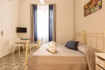 a small bedroom with a bed and a desk at Il Tarì Apartment in Palermo