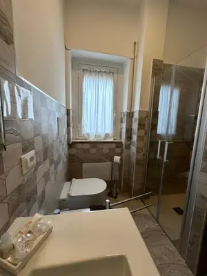 a bathroom with a toilet and a sink and a shower at Suite Vera in Palermo
