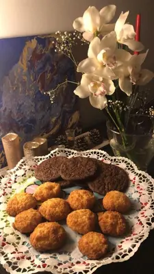 a table with a plate of food and a vase with flowers at Suite Vera in Palermo