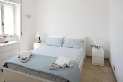 a white bedroom with a bed with towels on it at Suite Vera in Palermo