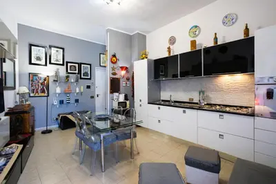 a kitchen with a glass table and white cabinets at Hola Cathedral House in Palermo