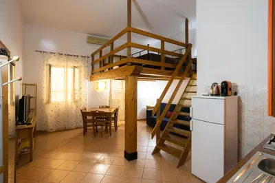a room with a loft bed in a kitchen with a table at Hola Cathedral House in Palermo