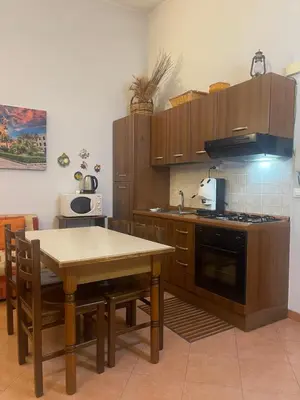 a kitchen with wooden cabinets and a table and a stove at Hola Cathedral House in Palermo