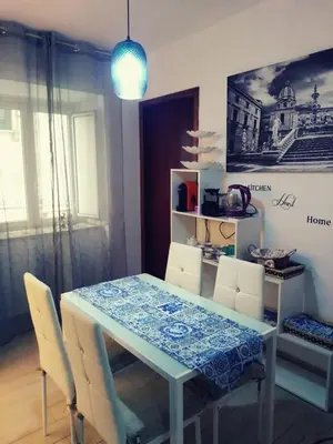 a dining room with a blue table and chairs at Hola Cathedral House in Palermo