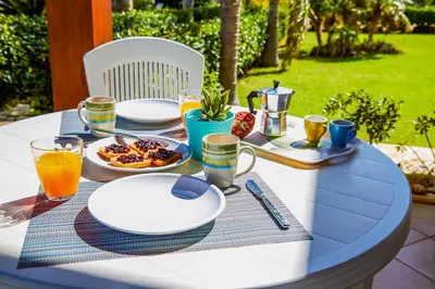 a table with plates of food and drinks on it at Residence I Faraglioni in Scopello