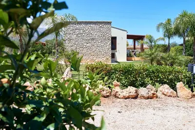 a garden with rocks in front of a house at Residence I Faraglioni in Scopello