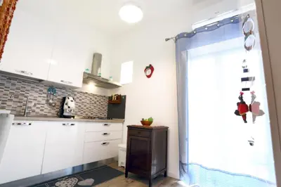 a kitchen with white cabinets and a window at Sol&Luna 1909 in Palermo