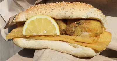 a sandwich with a lemon slice on top of it at Mondello's Pearl in Mondello