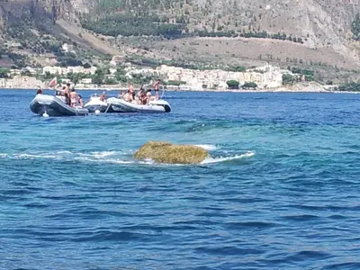 a group of people riding on a raft in the water at La Caletta in Santa Flavia