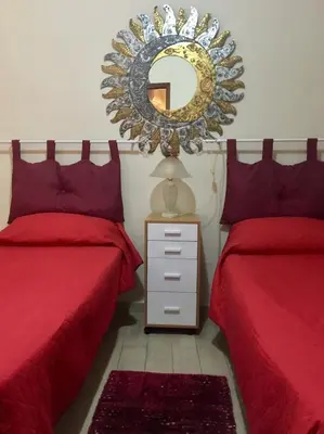 a bedroom with two beds and a mirror on the wall at Hello Cathedral House in Palermo