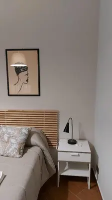 a bedroom with a bed and a table with a lamp at Apartament Home Lory in Palermo